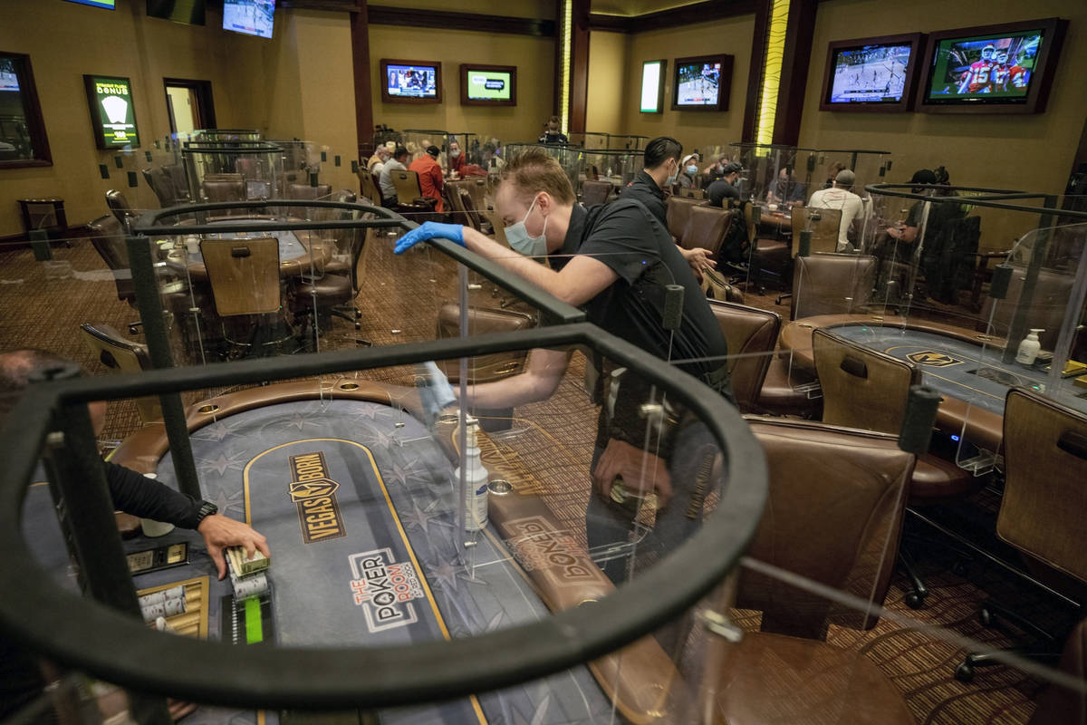 Poker dealer Daniel Wilson sanitizes plexiglass dividers, at the Red Rock Resort poker room in ...