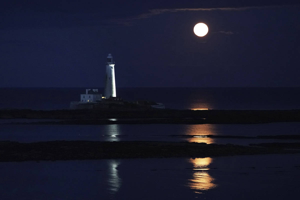 The full moon of August, known as the Sturgeon Moon, rises above St Mary's Lighthouse in Whitle ...