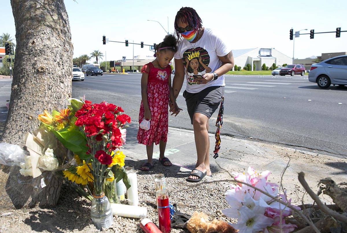 Tiffany Joseph and her daughter Jordan, 6, visit a makeshift roadside memorial on Wednesday, Au ...