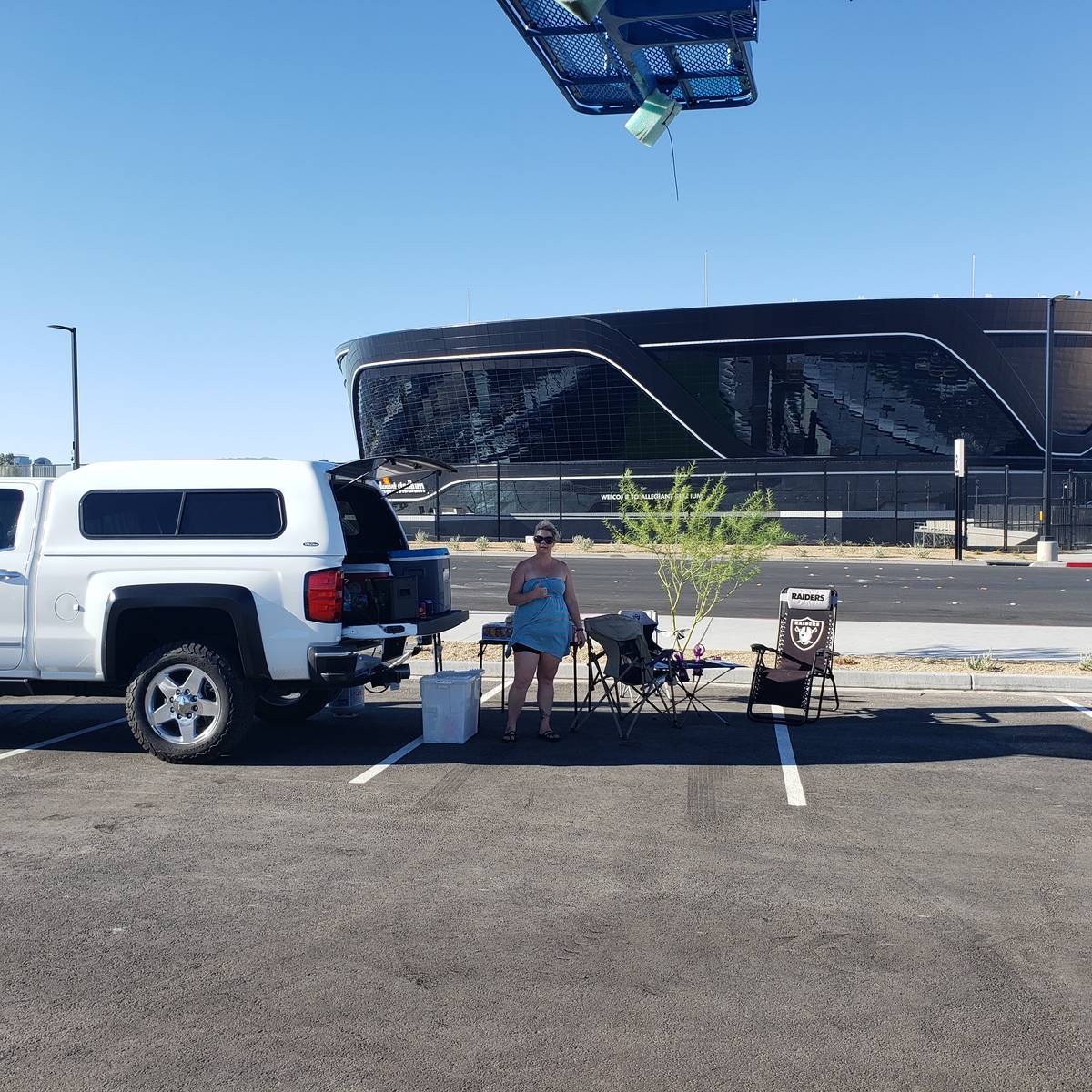 Tonie Silva stand with her tailgate spread with the recently completed Allegiant Stadium in the ...