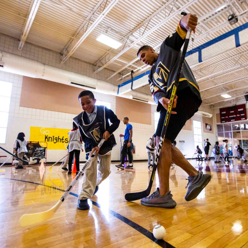 Eight-year-old Desmond Hester, left, plays with Golden Knights forward Ryan Reaves during a you ...