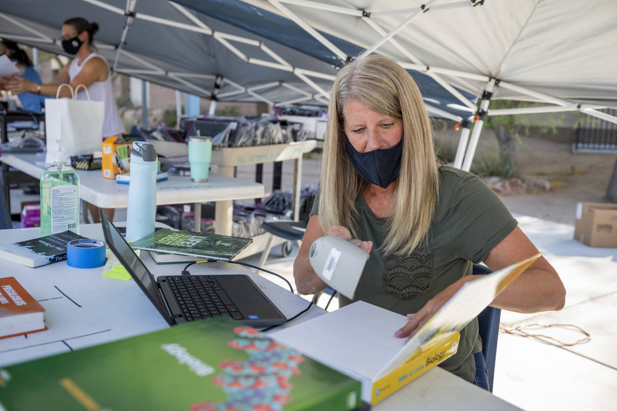 Carri Fabden, 9th grade house secretary, scans in returned text books from students while the s ...