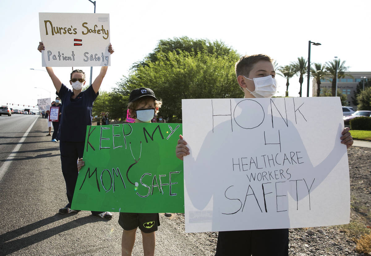 Oliver Smith, 10, right, his brother Elliot, 6, picket with their mother Registered Nurse, Ande ...