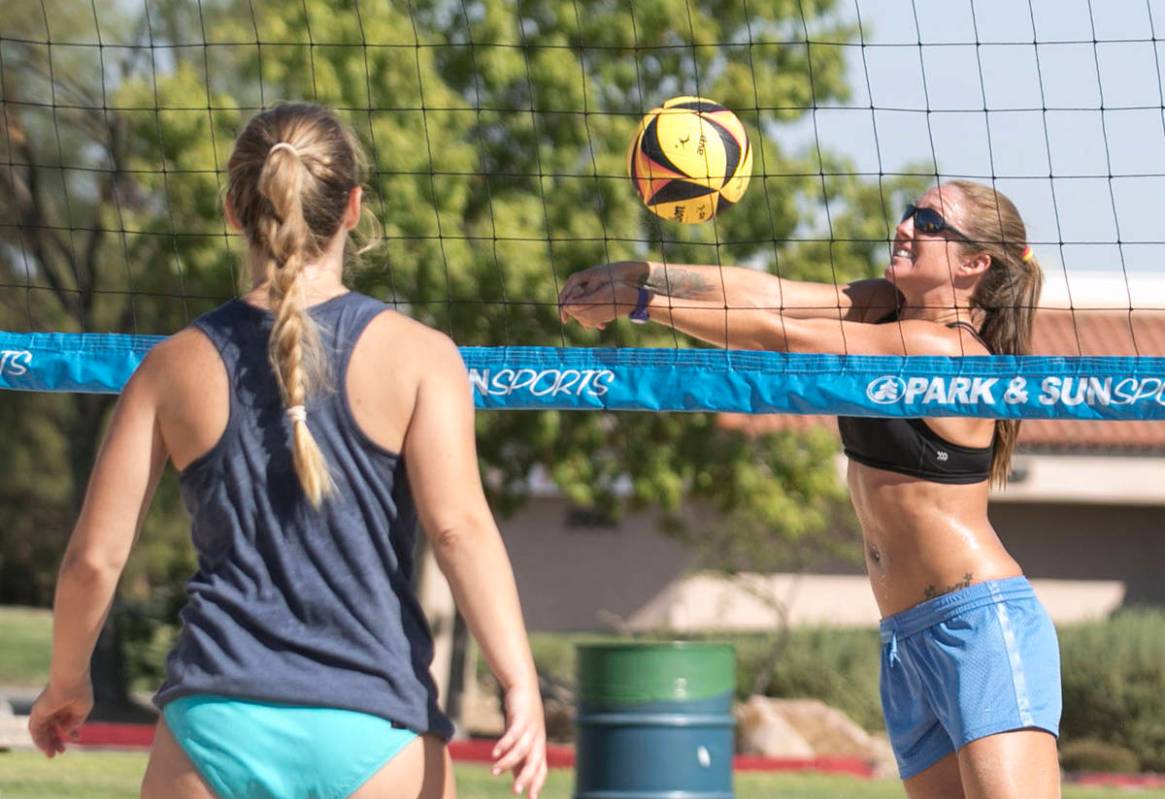 Lindsay Hostetler returns the ball as Elisabeth Rice, left, looks on as they play beach volleyb ...