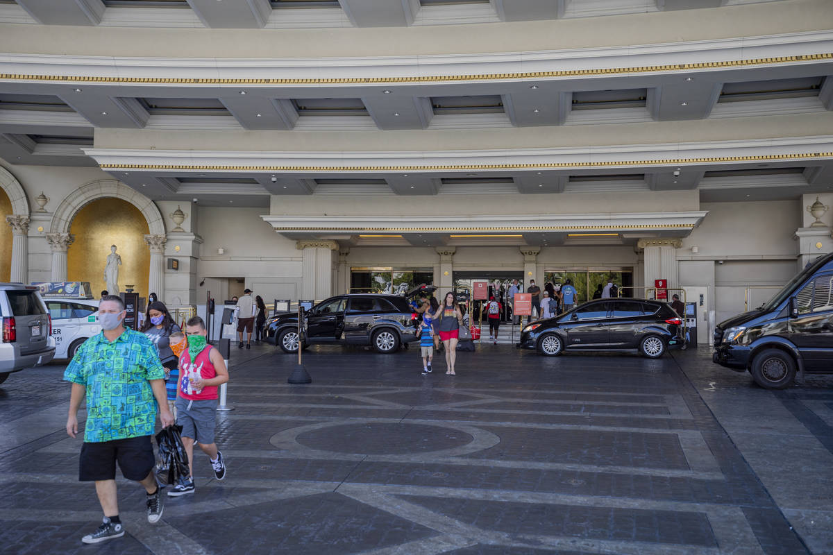 Guests leave Caesars Palace hotel and casino on the Las Vegas Strip, Thursday, Aug. 6, 2020, in ...
