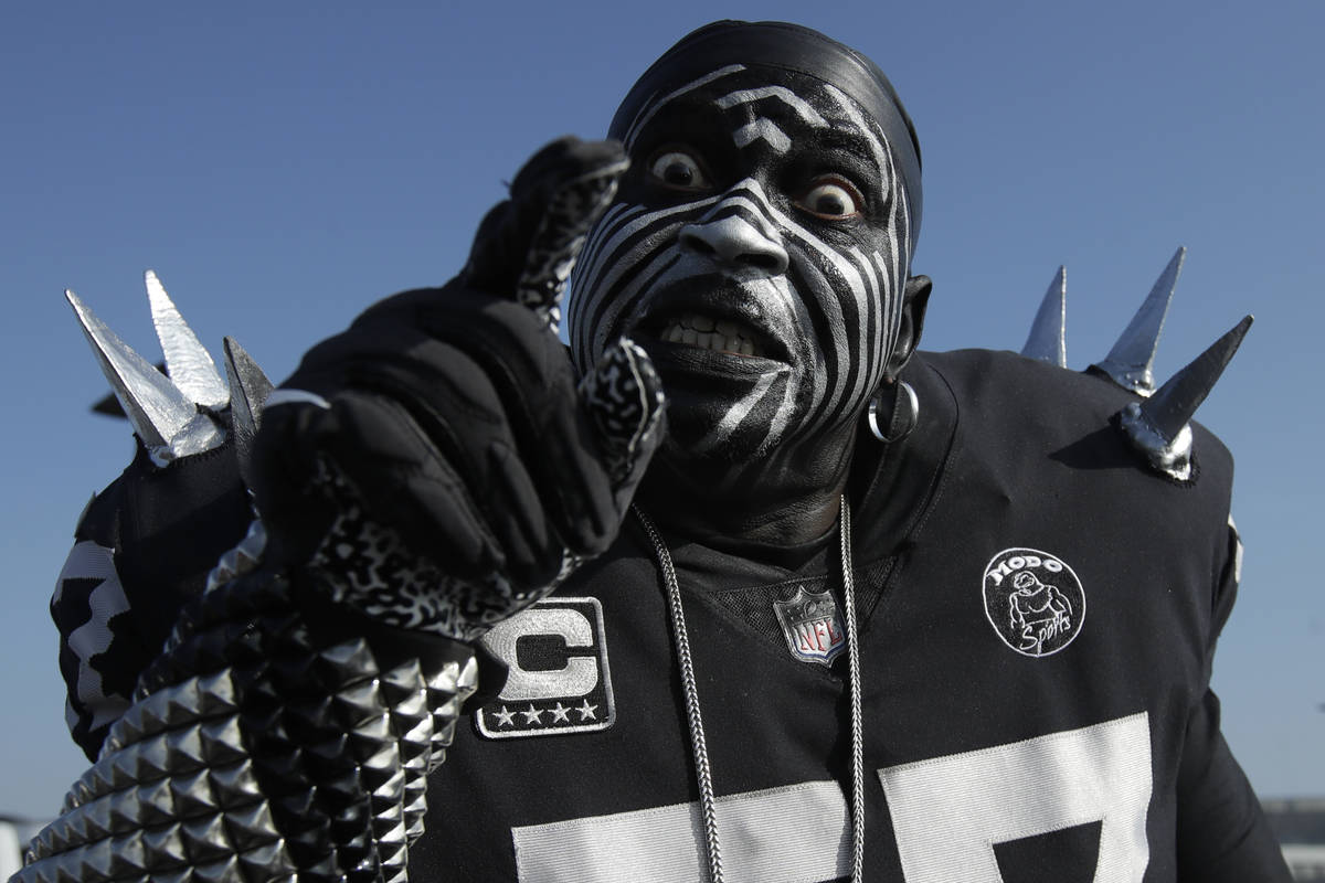 Oakland Raiders fan Violator poses for photos while tailgating at RingCentral Coliseum before a ...