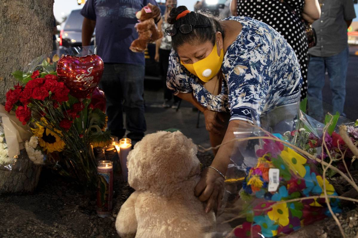 Minerva Rodriguez places a teddy bear with a group of candles during a vigil for Nelly Amaya-Ra ...