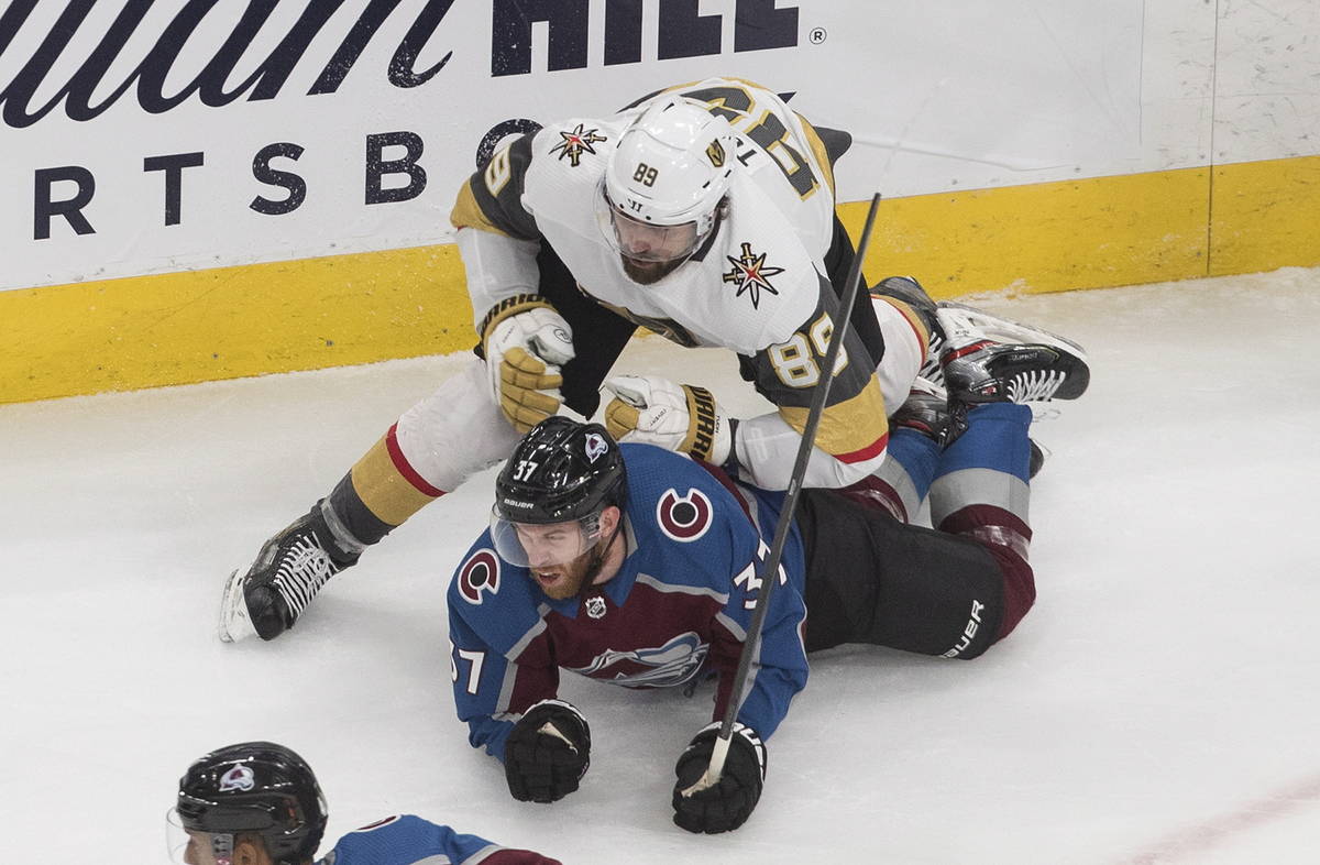 Colorado Avalanche's J.T. Compher (37) is checked by Vegas Golden Knights' Alex Tuch (89) durin ...