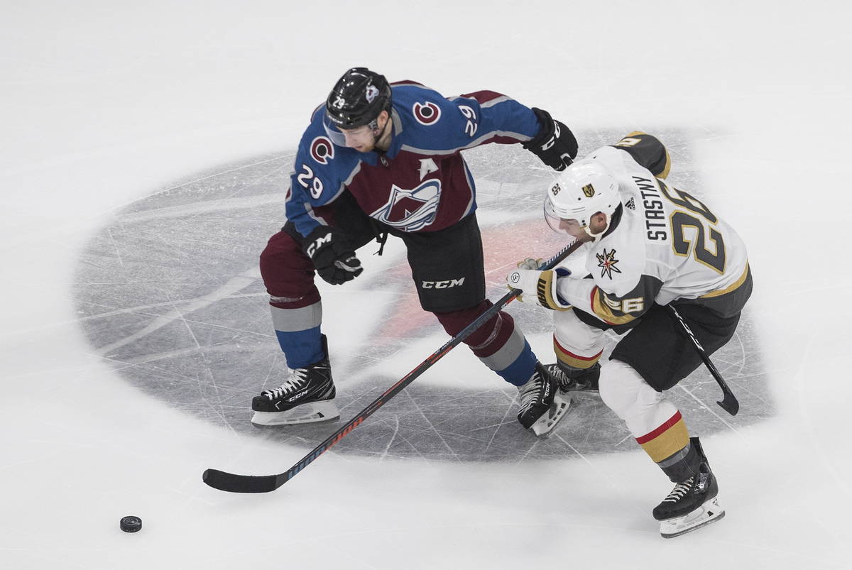 Colorado Avalanche's Nathan MacKinnon (29) and Vegas Golden Knights' Paul Stastny (26) battle f ...