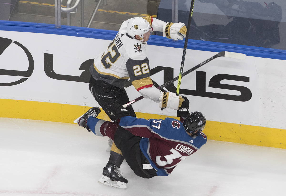 Colorado Avalanche's J.T. Compher (37) is checked by Vegas Golden Knights' Nick Holden (22) dur ...