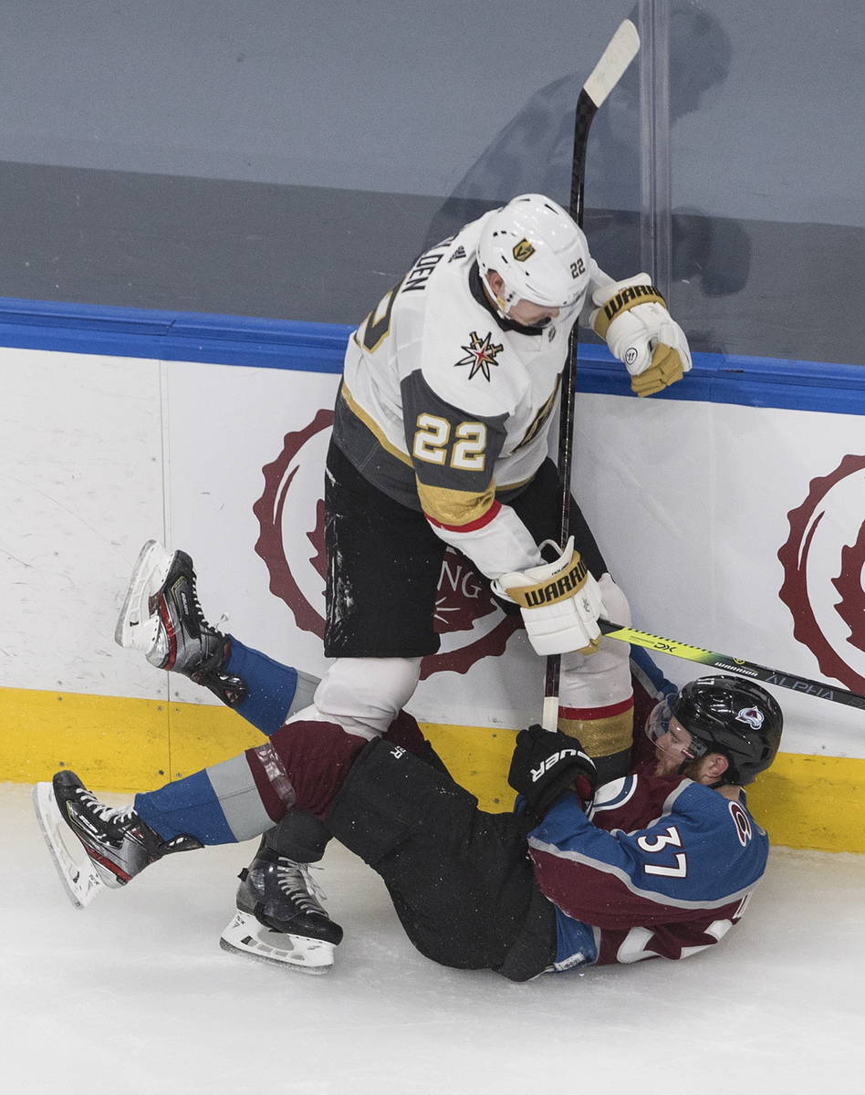 Colorado Avalanche's J.T. Compher (37) is checked by Vegas Golden Knights' Nick Holden (22) dur ...