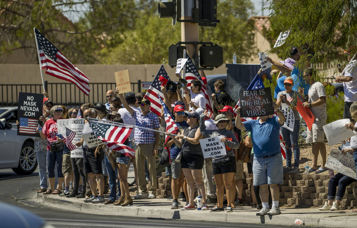 Supporters line the sidewalks during a No Mask Nevada rally to oppose the face mask mandate and ...