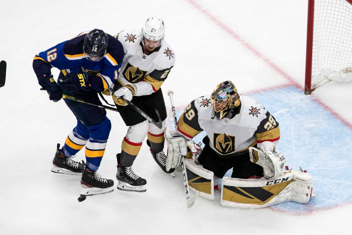 St. Louis Blues' Zach Sanford (12) and Vegas Golden Knights' Shea Theodore (27) battle in front ...