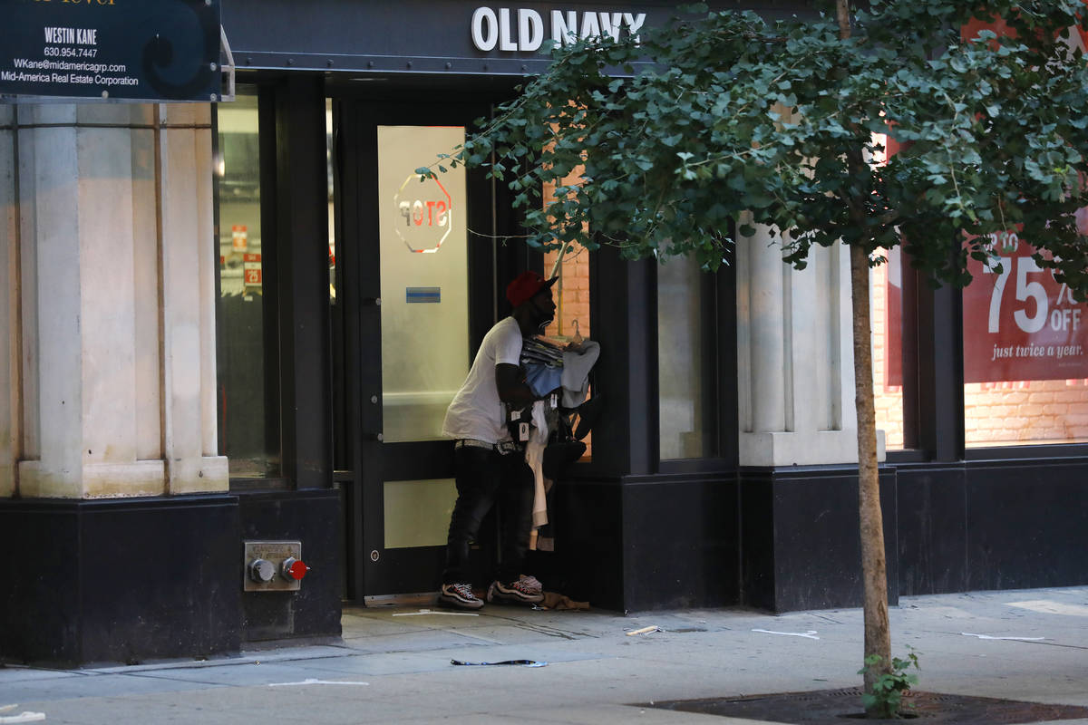A person exits an Old Navy store in the Chicago Loop with an armful of clothing in the early mo ...