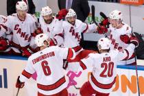 Carolina Hurricanes center Sebastian Aho (20) is congratulated by teammates Joel Edmundson (6) ...