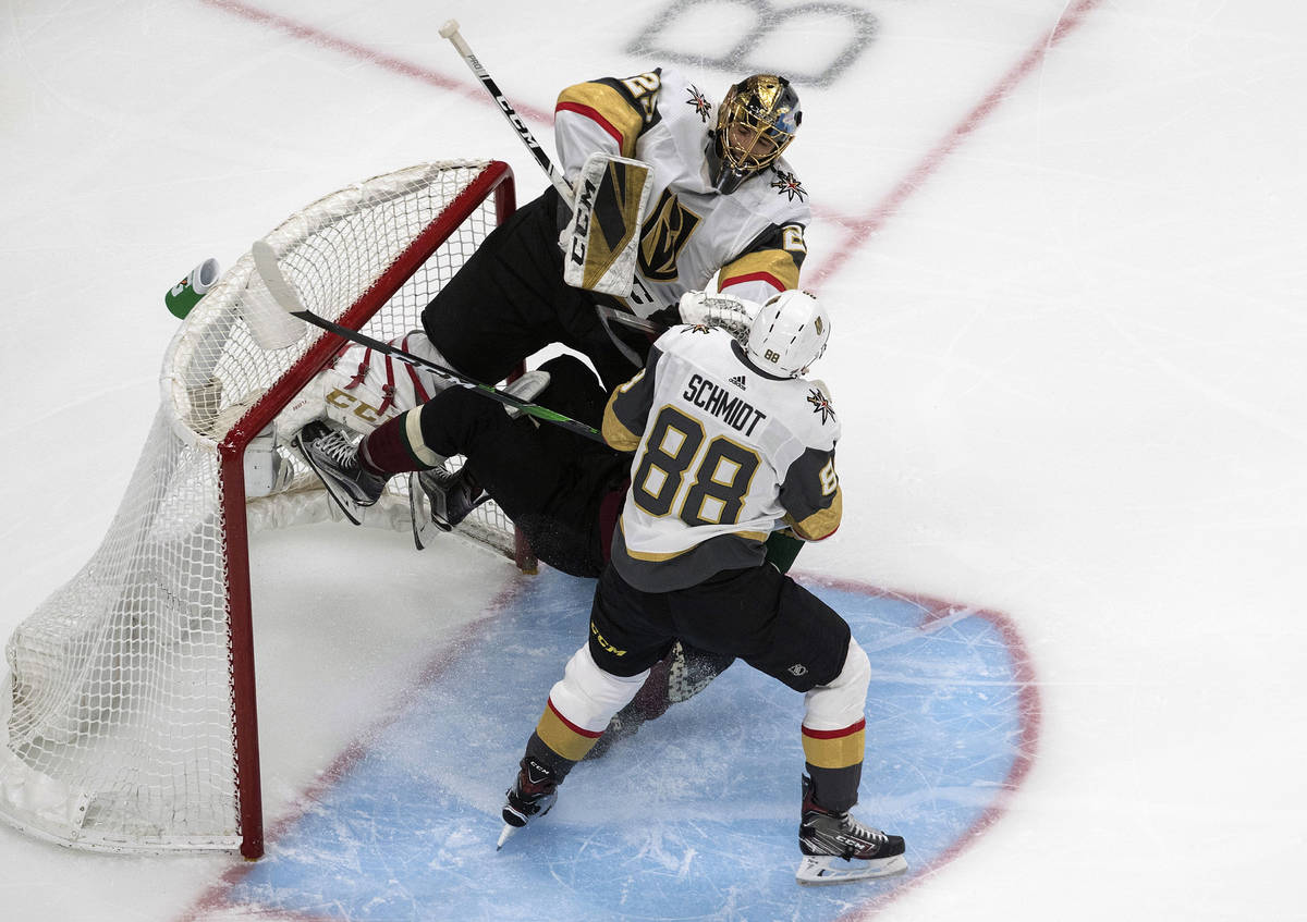 Arizona Coyotes' Taylor Hall (91) crashes into Vegas Golden Knights goalie Marc-Andre Fleury (2 ...