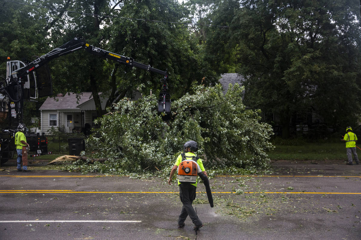 Des Moines city crews remove a tree fallen on Hickman Road, on Monday, Aug. 10, 2020, in Des Mo ...