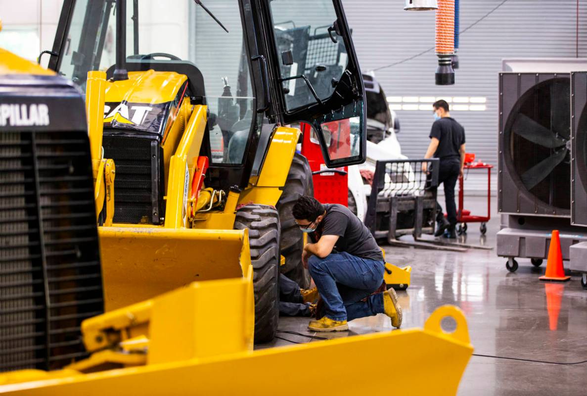 Student Samuel Branch, of Henderson, checks on his partner while working on a backhoe loader du ...