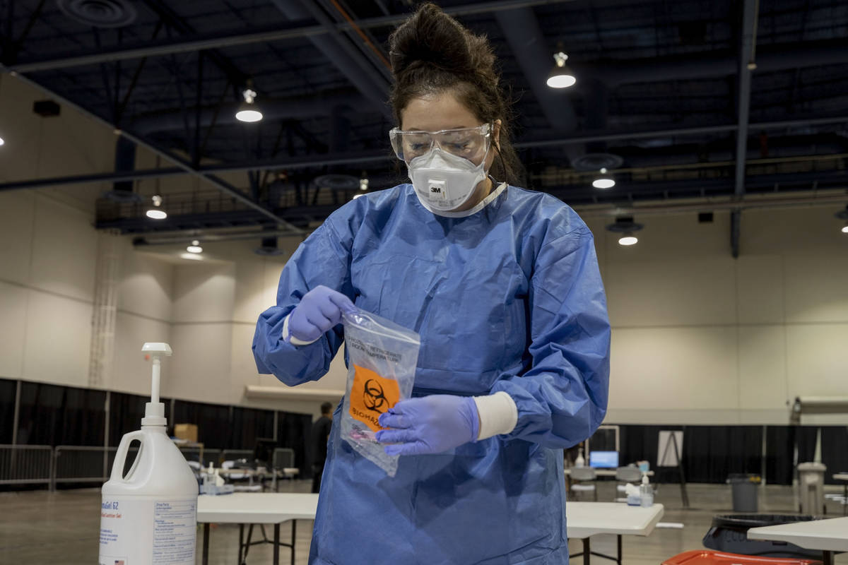 In this Aug.3, 2020, file photo, UMC respiratory therapist Diana Vega seals a COVID-19 test in ...