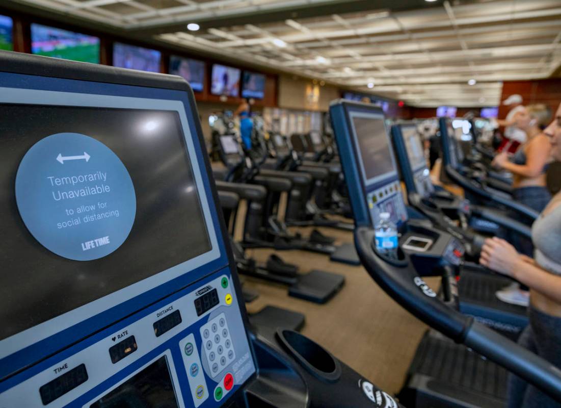 A social distancing sign is seen on a treadmill at Life Time Fitness located in Henderson on Tu ...