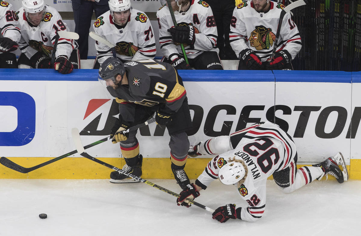 Chicago Blackhawks' Alex Nylander (92) is checked by Vegas Golden Knights' Nicolas Roy (10) dur ...