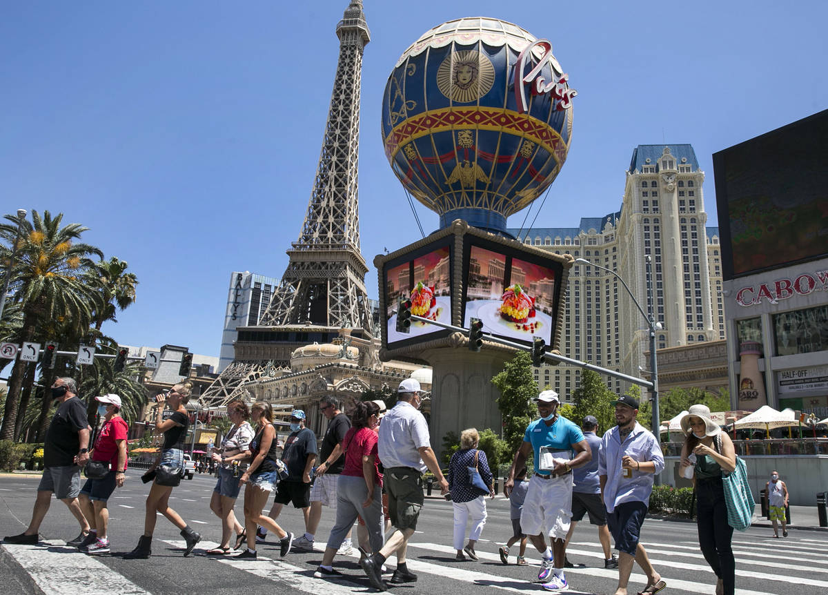 In this July 3, 2020, file photo, tourists cross Las Vegas Boulevard near Paris hotel-casino on ...