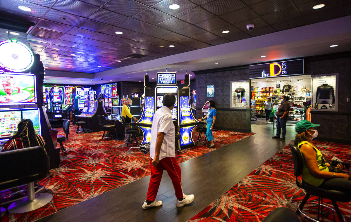 Patrons walk the casino floor as others play slots at the D Las Vegas on Tuesday, Aug. 11, 2020 ...