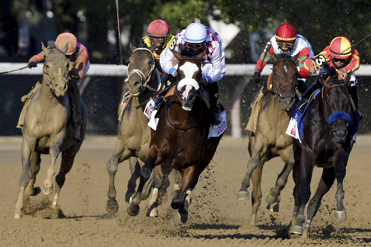 Tiz the Law, with Manny Franco up, center, leads the pack around the final turn on his way to w ...