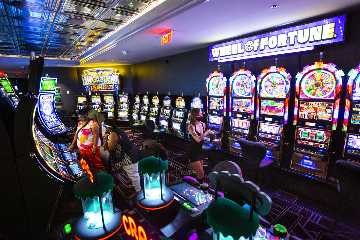 A cocktail waitress walks by slot machines at the D Las Vegas on Tuesday, Aug. 11, 2020. (Chase ...