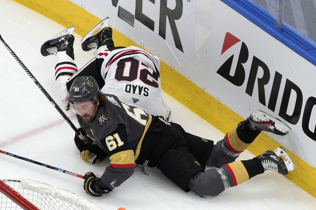 Vegas Golden Knights' Mark Stone (61) lands on top of Chicago Blackhawks' Brandon Saad (20) dur ...