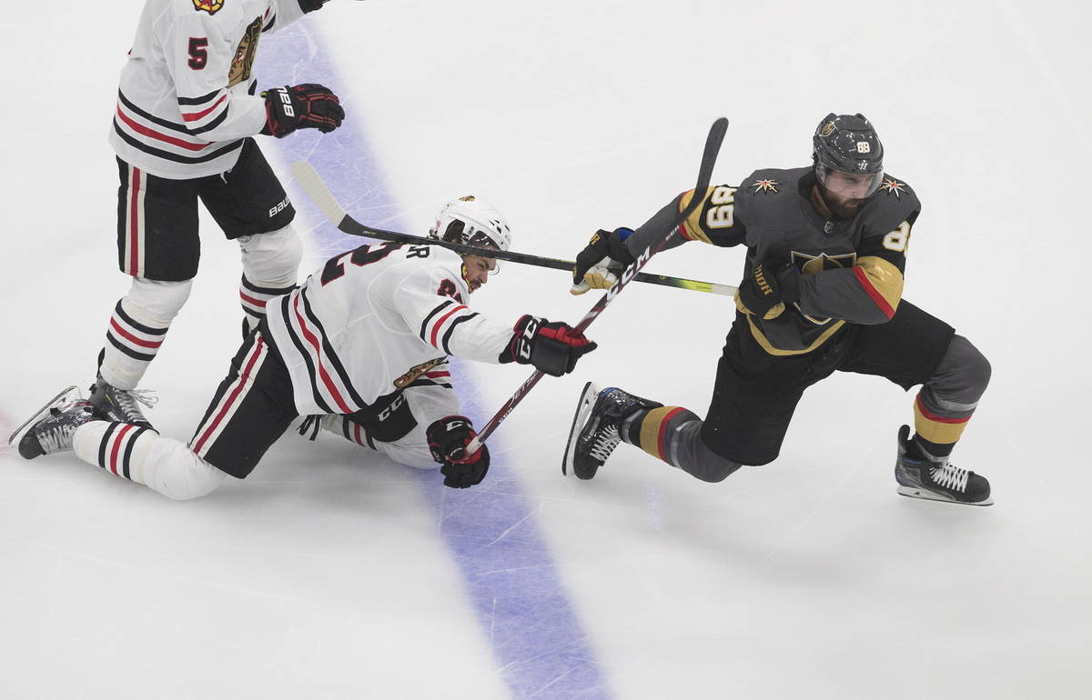 Vegas Golden Knights' Alex Tuch (89) and Chicago Blackhawks' Ryan Carpenter (22) battle for the ...