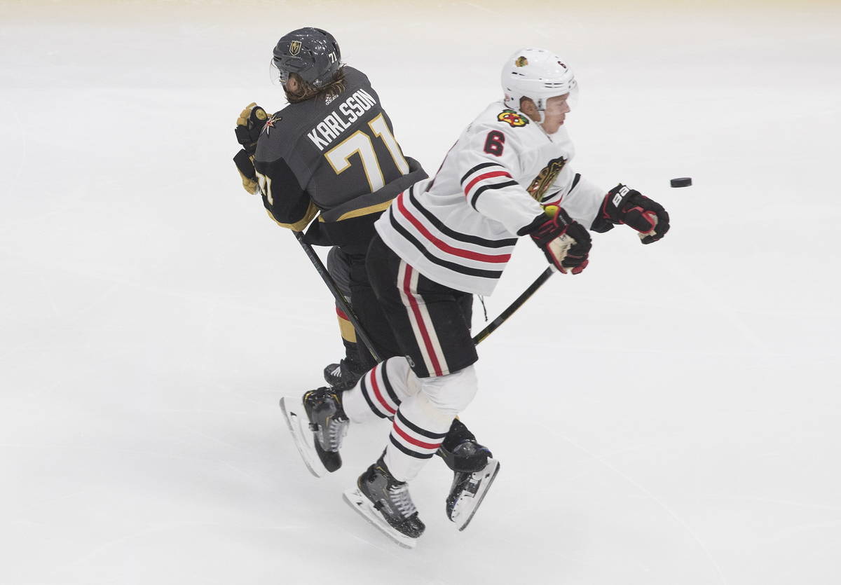 Vegas Golden Knights' William Karlsson (71) and Chicago Blackhawks' Olli Maatta (6) battle for ...