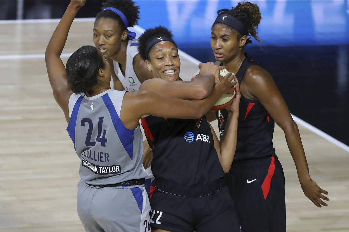 Las Vegas Aces' A'ja Wilson (22) fights for the ball with Minnesota Lynx's Napheesa Collier (24 ...