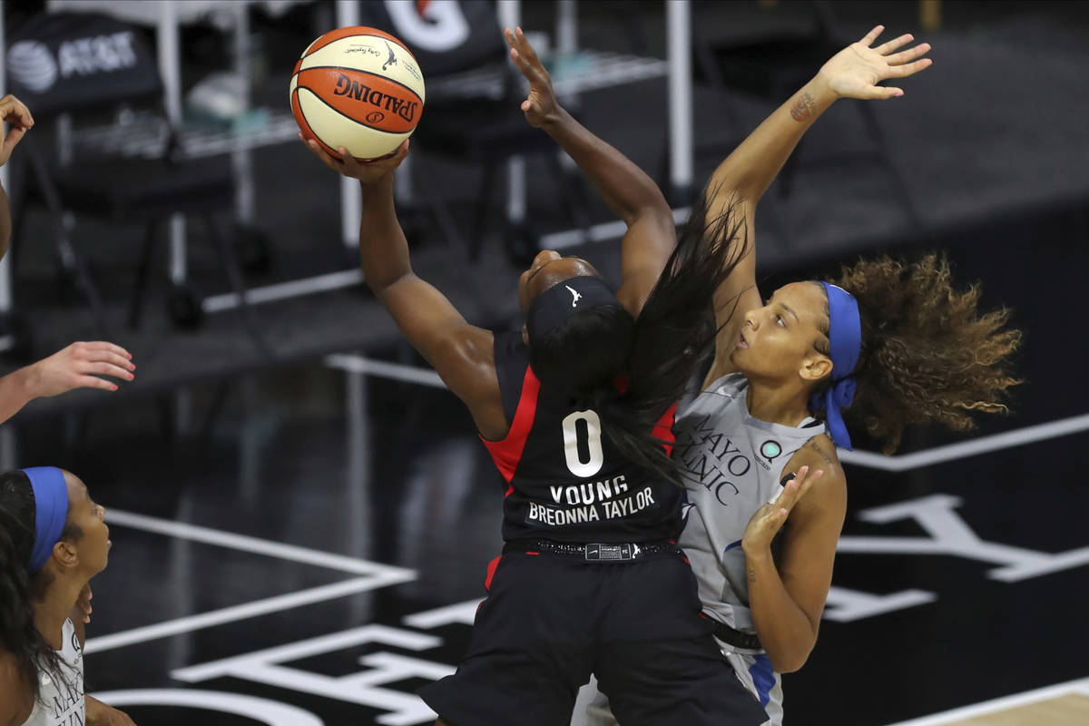 Las Vegas Aces' Jackie Young (0) shoots past Minnesota Lynx's Mikiah Herbert Harrigan during th ...