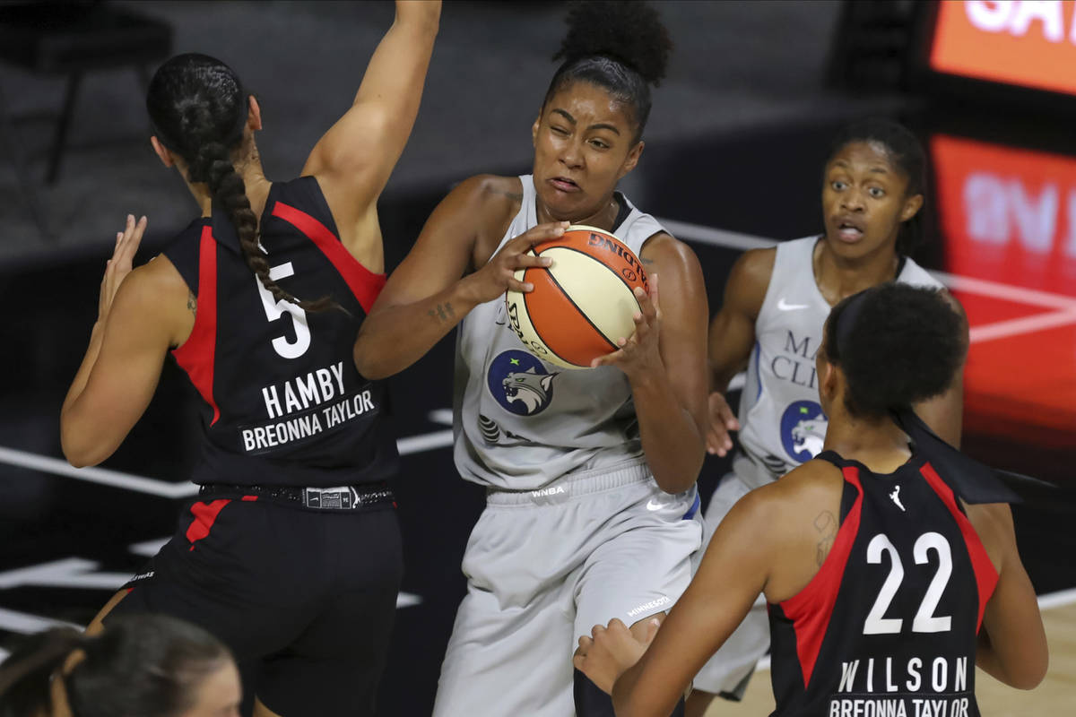 Minnesota Lynx's Damiris Dantas, center, grabs a rebound between Las Vegas Aces' Dearica Hamby ...