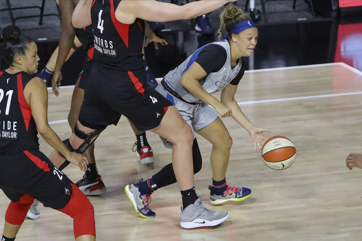 Minnesota Lynx's Rachel Banham, right, drives under the defense of Las Vegas Aces' Carolyn Swor ...