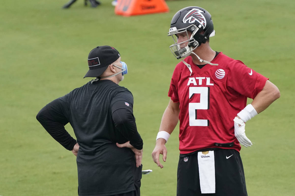 Atlanta Falcons head coach Dan Quinn talks with quarterback Matt Ryan during an NFL football tr ...
