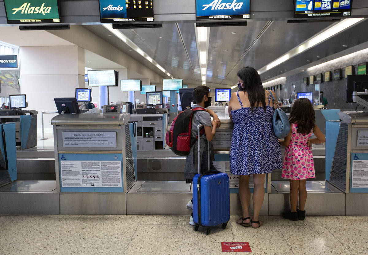 Cynthia Noriega and her two children, Evan York, 11, and Sarah York, 7, check in for Evan's fli ...