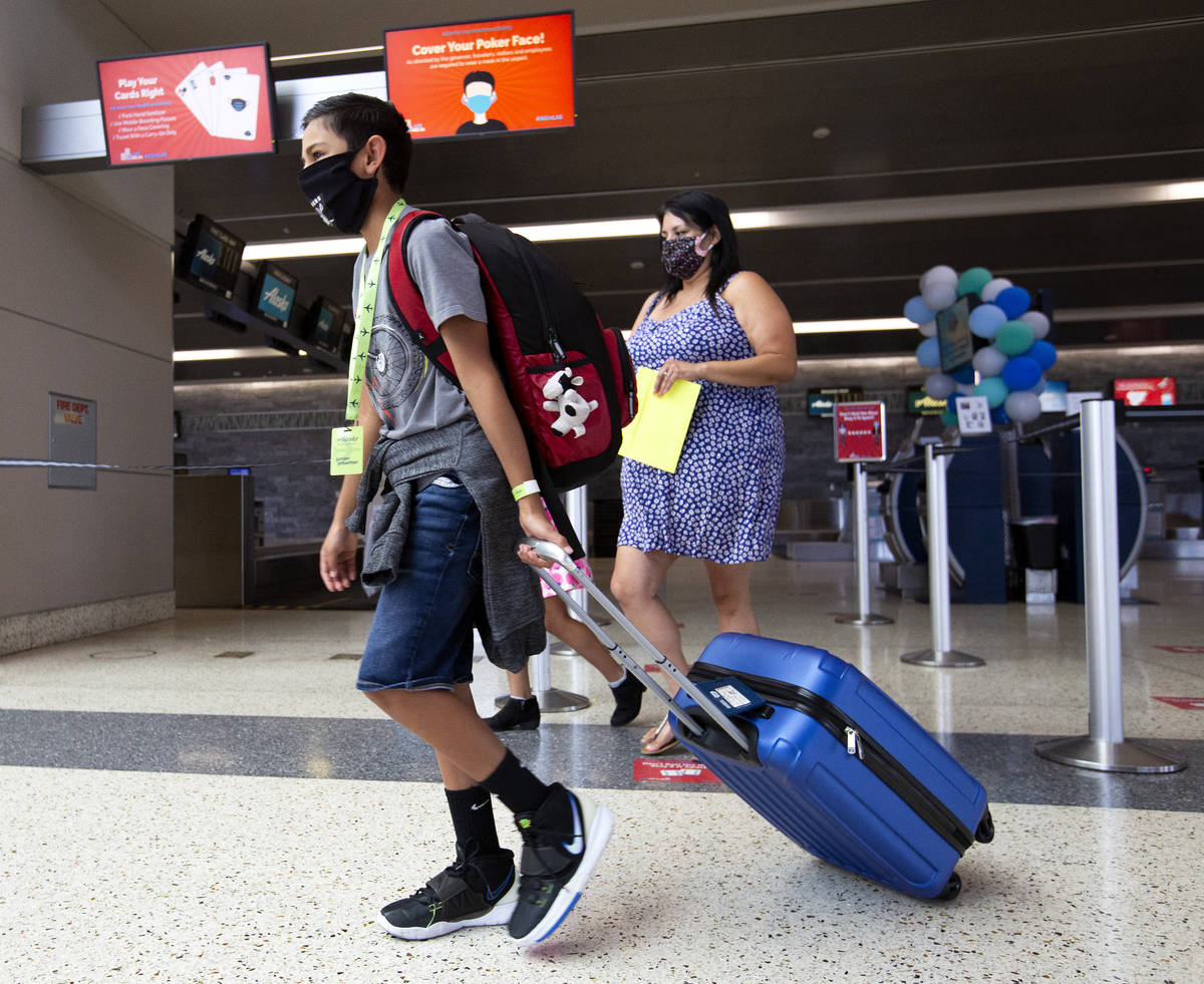 Evan York, 11, makes his way toward security before flying to his father's house in Washington ...