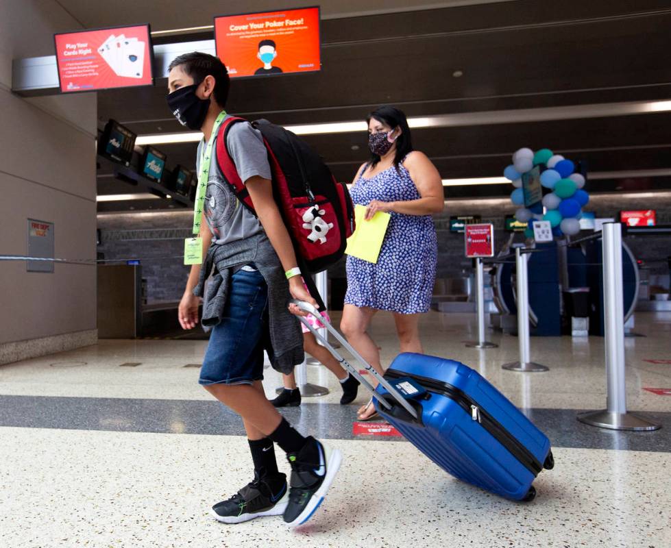 Evan York, 11, makes his way toward security before flying to his father's house in Washington ...