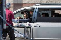 A Clark County School District worker distributes school food donations for students or parents ...