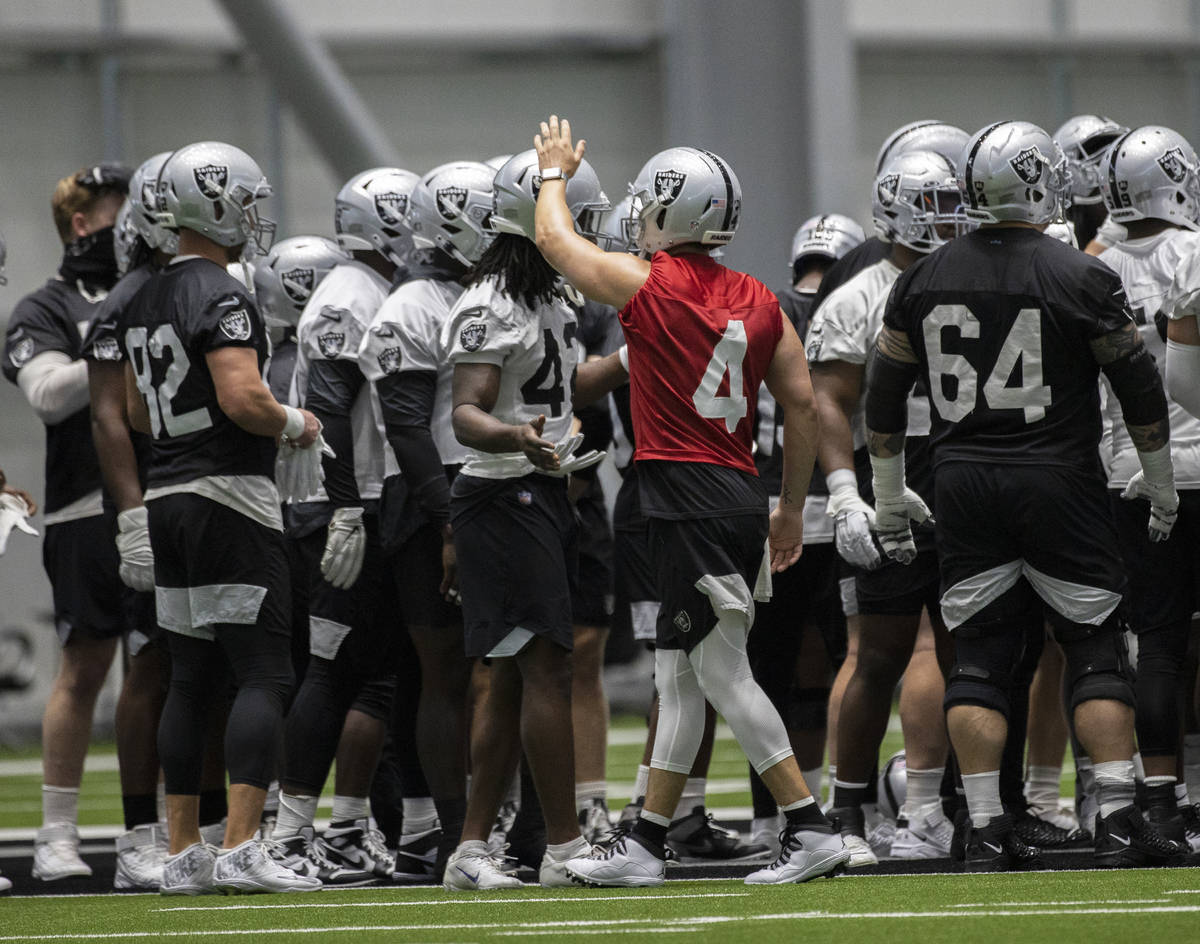 Raiders quarterback Derek Carr (4) leads stretching during an NFL football training camp practi ...