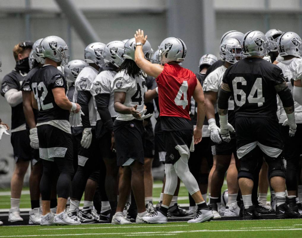 Raiders quarterback Derek Carr (4) leads stretching during an NFL football training camp practi ...