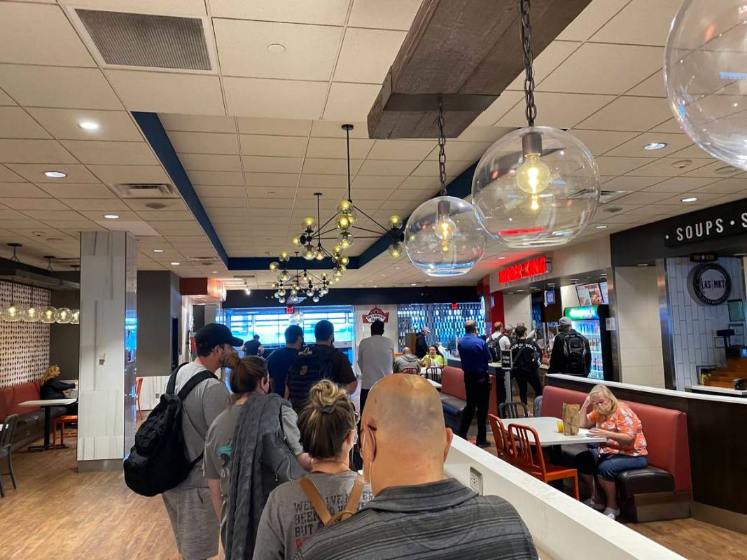 Travelers wait in line at a Burger King in Terminal 1 at McCarran International Airport on July ...