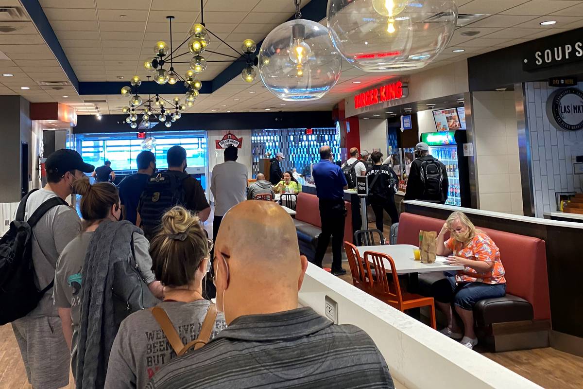 Travelers wait in line at a Burger King in Terminal 1 at McCarran International Airport on July ...