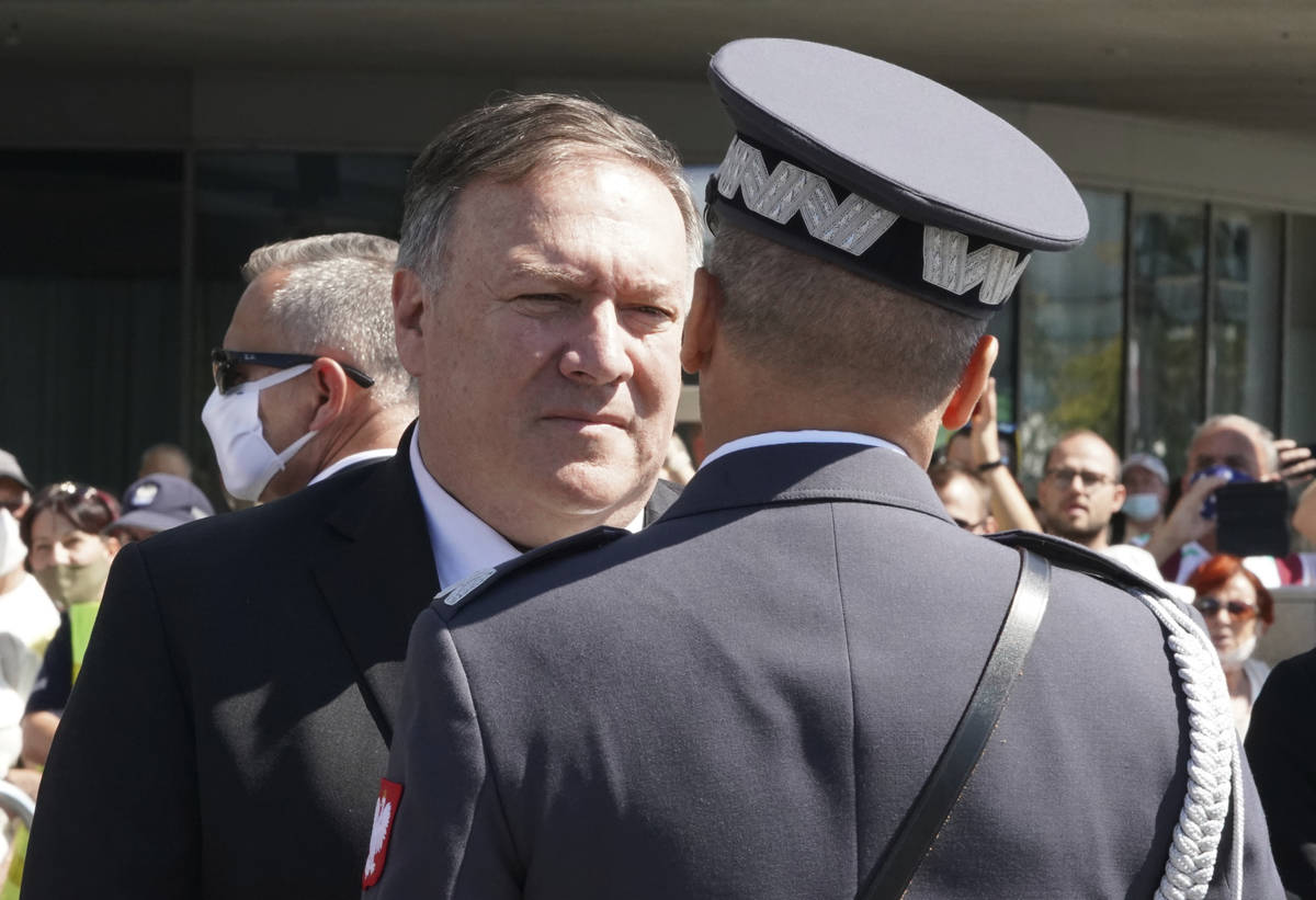 US Secretary of State Mike Pompeo talks to an officer at Pilsudski square in Warsaw, Poland, be ...