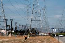 A jogger runs in extreme heat under high tension electrical lines in the North Hollywood sectio ...