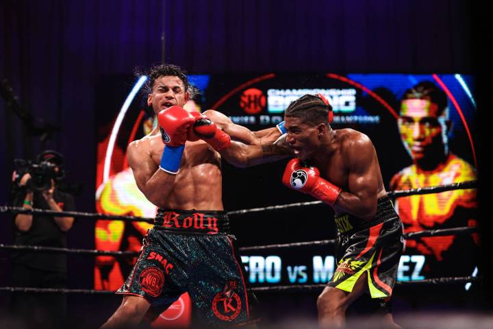 Rolando Romero takes a punch from Jackson Marinez during their WBA interim lightweight title fi ...