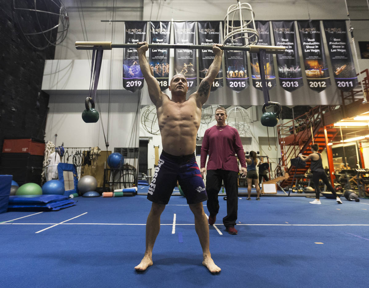 Gymnast Mirek Niepielski, left, does overhead squats under the supervision of Steve McCauley, h ...