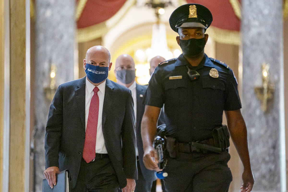 FILE - In this Aug. 5, 2020, file photo Postmaster General Louis DeJoy, left, is escorted to Ho ...